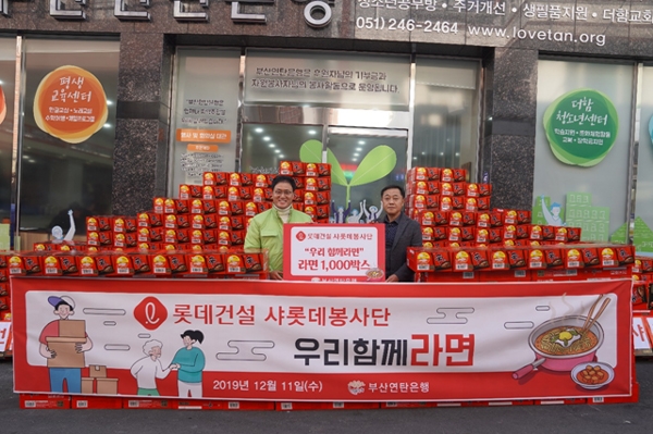 강정칠 부산연탄은행 대표(좌측)와 박대환 롯데건설 영남지사장(우측)이 사랑의 라면 나눔 기념 촬영 중이다