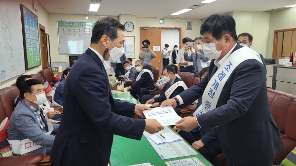 ▲대한건설단체총연합회를 대표해 하용환 대한건설협회 경기도회장(사진 오른쪽)이 경기도의회 김명원 건설교통위원회 위원장(왼쪽)에게 ‘경기도의 100억원 미만 공사에 대한 표준시장단가 적용 추진 반대 성명서’를 제출했다./제공=대한건설협회