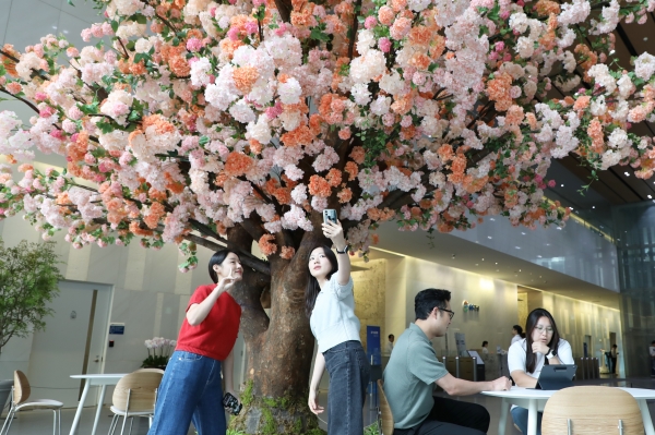 직원들이 점심시간을 이용해 동료들과 새단장한 로비에서 사진을 찍고 있다./사진=GS건설 제공